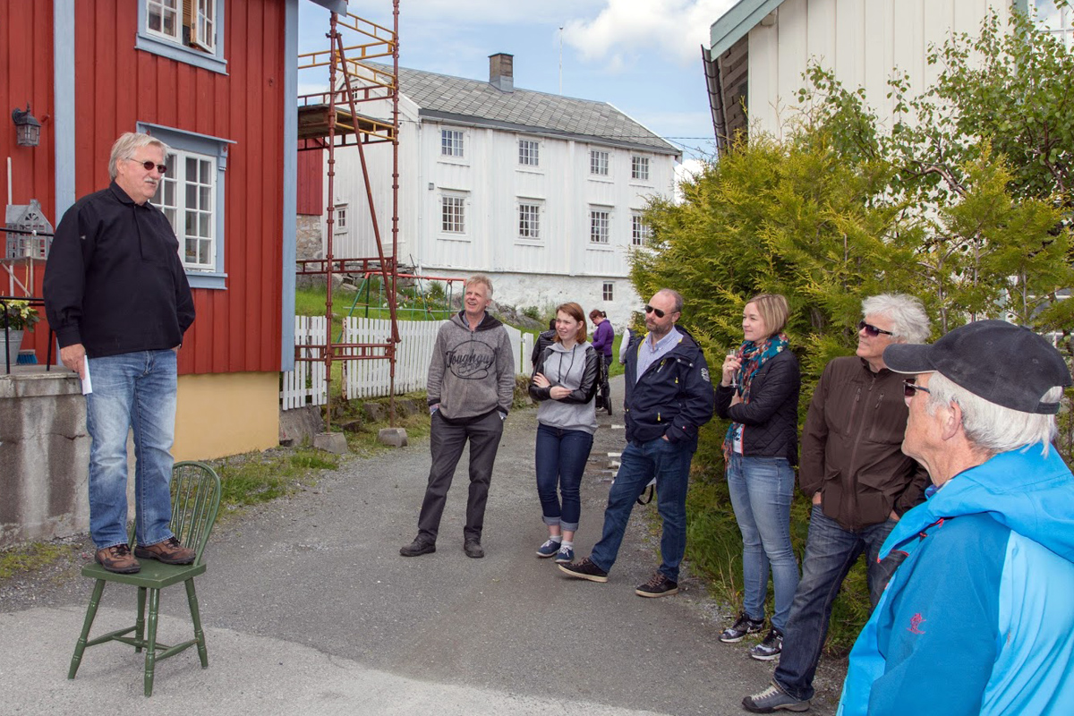 Roar Børø tok med forsamlingen på en historisk vandring ved bryggene der han fortalte noe av historiene bak de ulike bryggene og husene i Råkvågen.